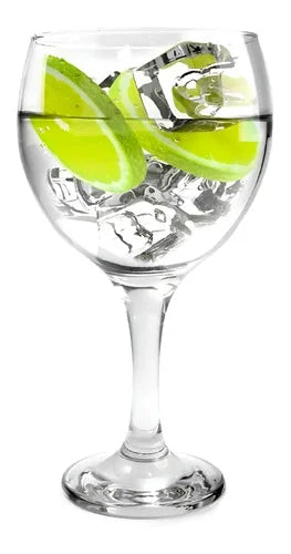 Gin tonic en copa balon de cristal transparente con hielo