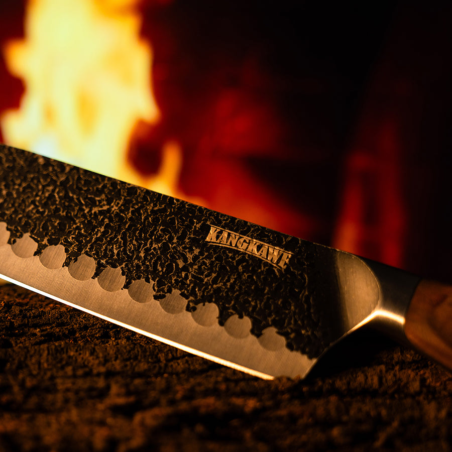 Cuchillo santoku Pulmahue martillado Kangkawe junto al fuego de la parrilla