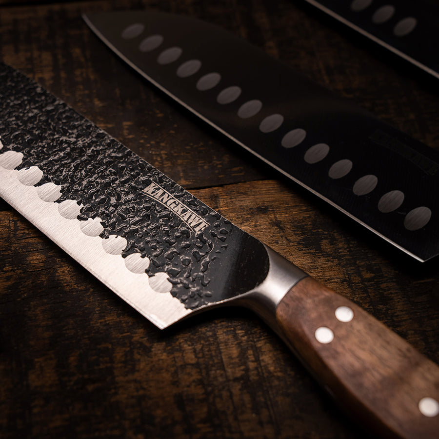 Cuchillo santoku Pulmahue martillado Kangkawe sobre tabla de madera para asado