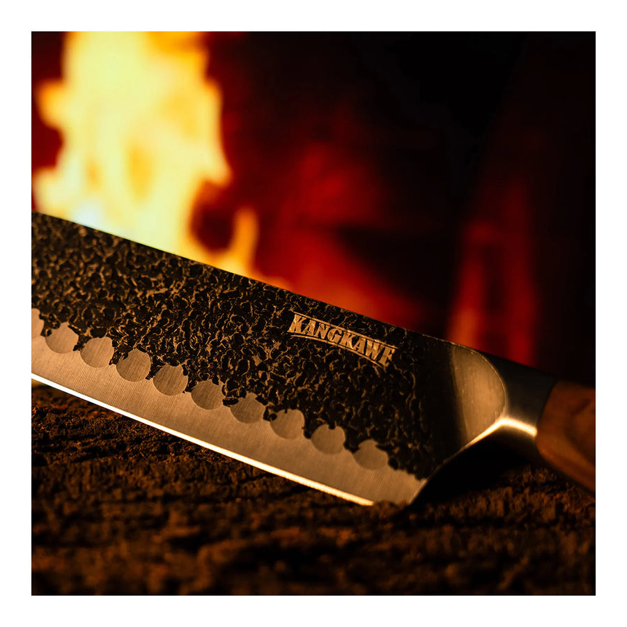 Cuchillo santoku Pulmahue martillado Kangkawe junto al fuego de la parrilla