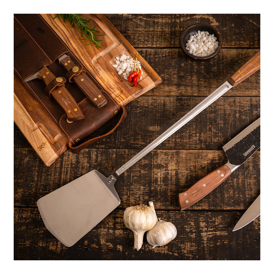 Espátula parrillera Pro XL Kangkawe sobre tabla de madera para asado