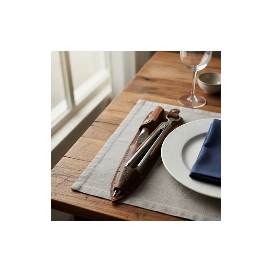 Set cuchillo Catemu y tenaza Kangkawe con funda de cuero café sobre una mesa puesta para asado