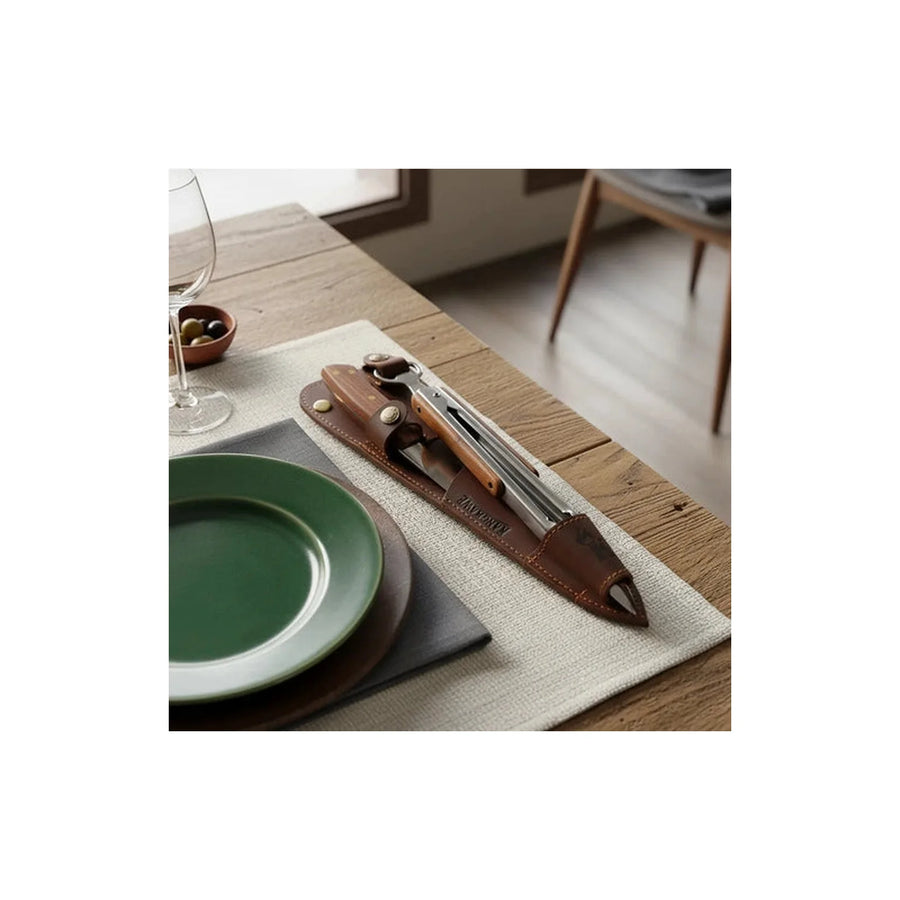 Set cuchillo Catemu y tenaza Kangkawe con funda de cuero café en una mesa servida