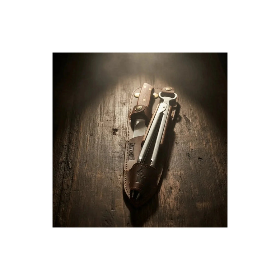 Set cuchillo Catemu y tenaza Kangkawe con funda de cuero café junto al fuego de la parrilla