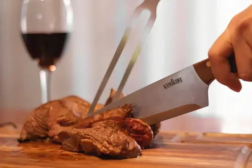 Set parrillero cuchillo y tenedor Kangkawe con funda de cuero cortando carne en pleno asado