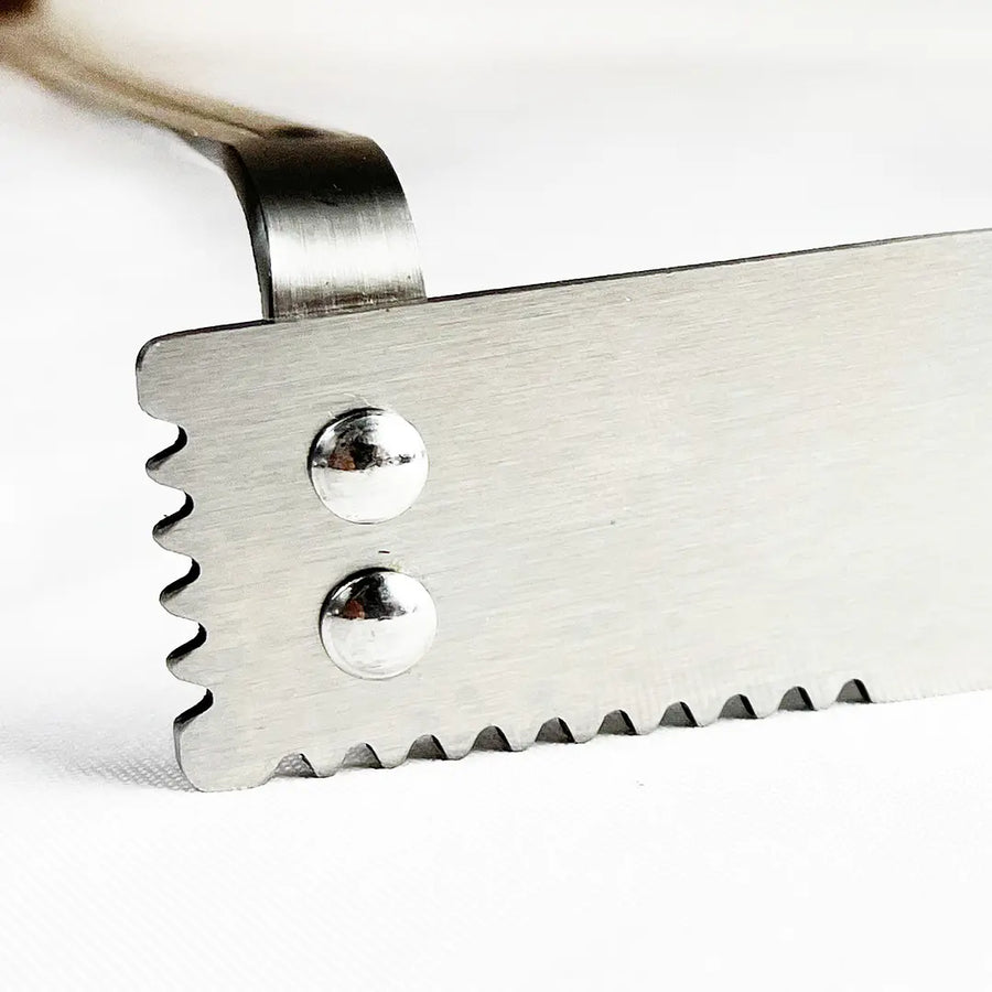 Detalle de la pala dentada del set parrillero Pro XL Kangkawe pala carbonera y atizador