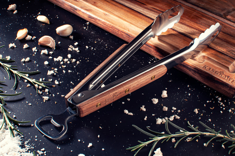 Tenaza parrillera Kangkawe sobre tabla de madera con especias para asado